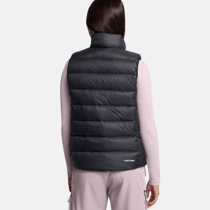 Back view of a person wearing a black Under Armour Storm puffer vest over a light pink long sleeve shirt