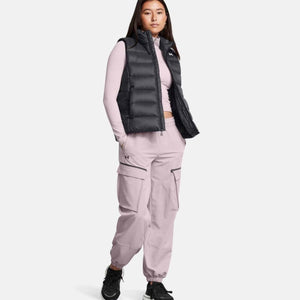Woman wearing Under Armour black puffer vest over light pink long sleeve top and matching cargo joggers