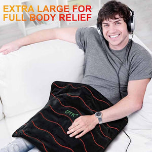 Man sitting on a sofa using an extra large UTK Technology heating pad