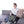 Woman sitting on a sofa using a UTK Technology infrared heating pad with jade stones