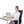 Woman sitting at a desk using a laptop with a UTK Technology heating pad on her office chair