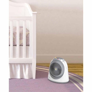 Vornado baby heater on a purple rug next to a white crib