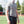 Man wearing a grey neck gaiter and athletic clothing standing on a running track