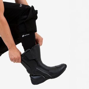 Person putting on a black Venture Heat motorcycle boot