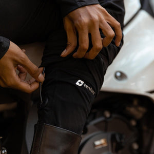 Person adjusting Venture Heat heated base layer pants with power cable