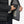 Person placing a Venture Heat battery pack into the interior pocket of a black puffer jacket