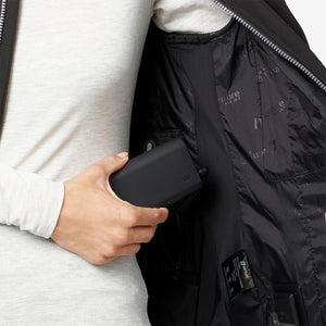 Hand placing a Venture Heat battery pack into the interior pocket of a heated jacket