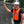 Worker wearing a Venture Heat orange safety vest and white hard hat standing by a chain link fence