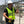 Construction worker wearing a Venture Heat safety vest and hard hat holding work gloves