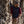 Man wearing a Venture Heat black vest and beanie leaning against a rock face with climbing gear