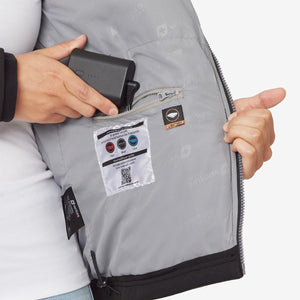 Person placing a Venture Heat battery pack into the interior pocket of a heated jacket