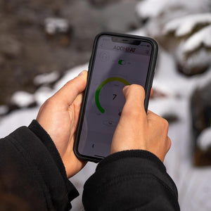 Person using Addheat mobile app to control temperature settings on smartphone