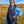 Person wearing a black Venture Heat heated vest over a blue hoodie in a grassy field