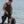 Man wearing Venture Heat vest and wetsuit standing by scuba tank on beach