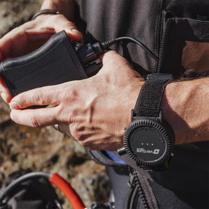 Person connecting a Venture Heat battery pack to a wearable device