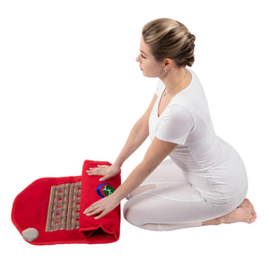 Woman kneeling and folding a red HealthyLine gemstone heating mat