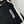 Hestra logo embroidered on black fabric with white leather trim