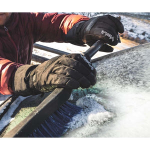 Person wearing Volt heated gloves brushing snow off a car windshield