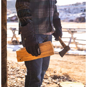 Person wearing black Volt heated gloves holding a piece of firewood and a small axe