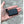 Small black rectangular battery pack with a short power cable and connector held in a palm