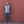 Man wearing a grey vest and beanie standing against a red brick wall