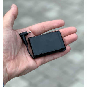 Volt Heat black rectangular rechargeable battery with attached charging cable held in palm