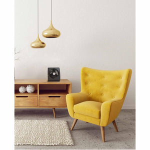Vornado air circulator fan on a wooden console table next to a yellow armchair