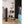 Vornado black tower fan standing on a wooden floor in a bedroom