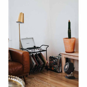 Vornado black air circulator fan on a wooden floor next to a record player stand and a potted cactus