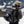 Person wearing a grey Kulkea backpack with a helmet stored in the exterior pocket against a snowy mountain background