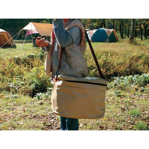 Person wearing a beige Snow Peak shoulder bag at a campsite