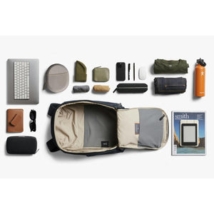 Bellroy backpack laid flat with organized travel accessories and personal items arranged around it