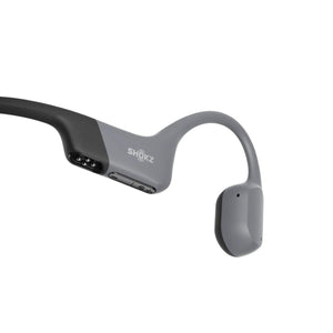 Shokz bone conduction headphones side view showing charging port and volume buttons
