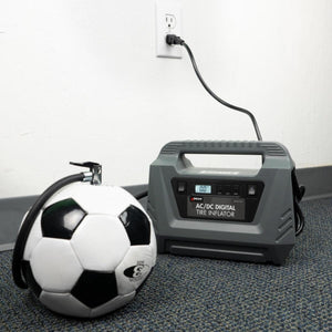 Wagan AC DC digital tire inflator plugged into a wall outlet and connected to a soccer ball