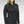 Woman wearing a black quarter zip pullover with red contrast stitching and a logo on the chest
