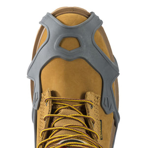 Winter Walking grey ice cleat traction device fitted over the toe of a tan work boot