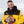 Man wearing a black and yellow Iowa Hawkeyes jacket holding a football