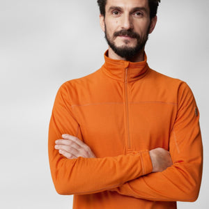 Man wearing an orange Fjallraven Abisko half zip fleece sweater with arms crossed
