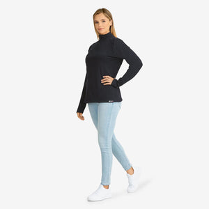 Woman wearing a black long sleeve quarter zip top with light blue jeans and white sneakers