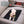 Small curly dog lying on a black polar fleece pet mat on a car seat