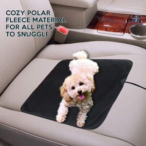 Small curly dog lying on a black polar fleece pet mat on a car seat