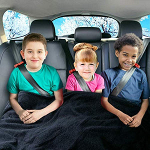 Three children sitting in a car back seat covered by a Zone Tech black fleece blanket